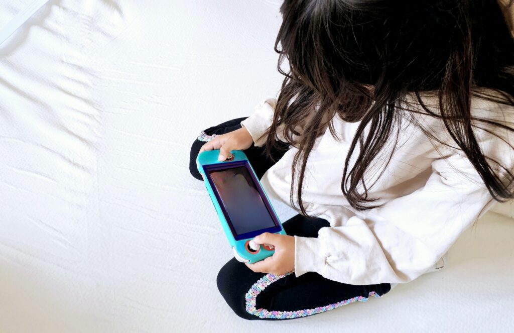 俯いてゲームをしている子供